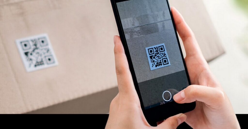 携帯電話で QR コードを読み取っている画像