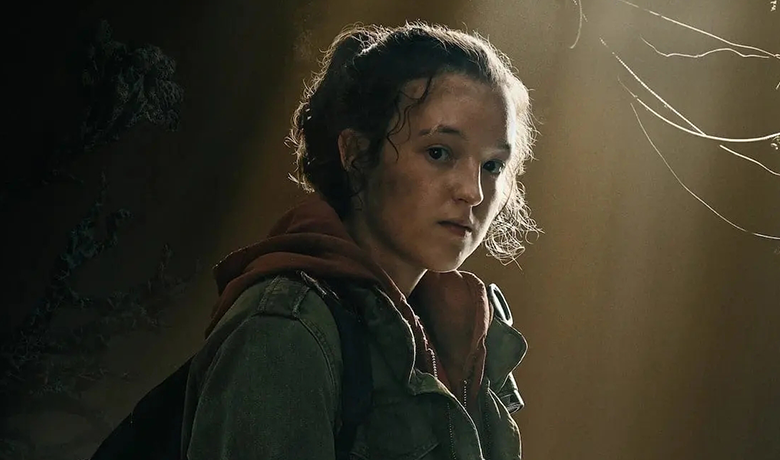 The character Ellie looking at the camera with a denim jacket and her hair tied up.