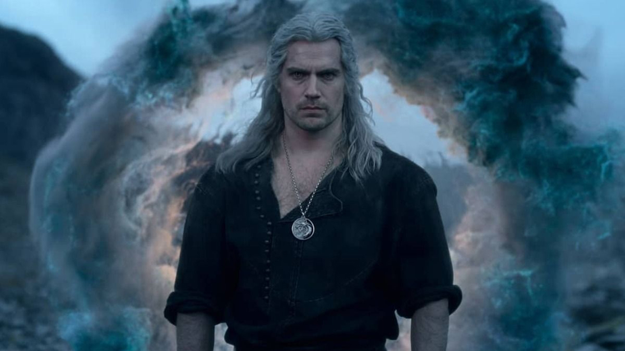 El personaje Geralt con camisa negra y collar mirando a la cámara con expresión seria.