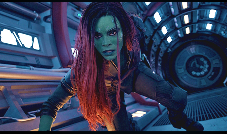 A personagem Gamora fugindo por um corredor da nave pronta para batalhar