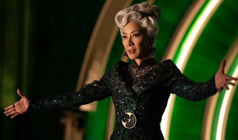 Le personnage Madame Morrible à bras ouverts sur fond vert.