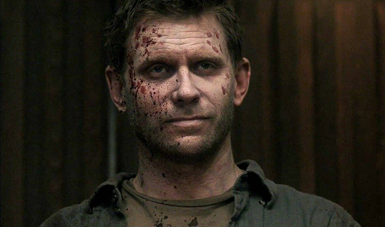 The character Lucifer with a half smile and a wound on his face.