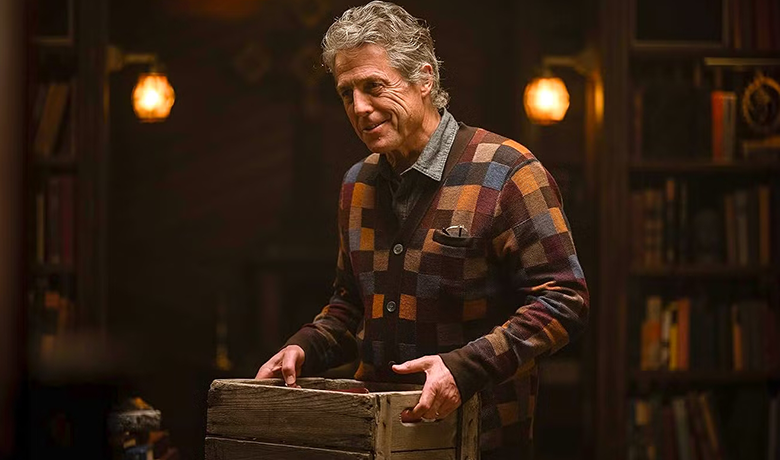 The character Mr. Reed holding a box and wearing a plaid coat.