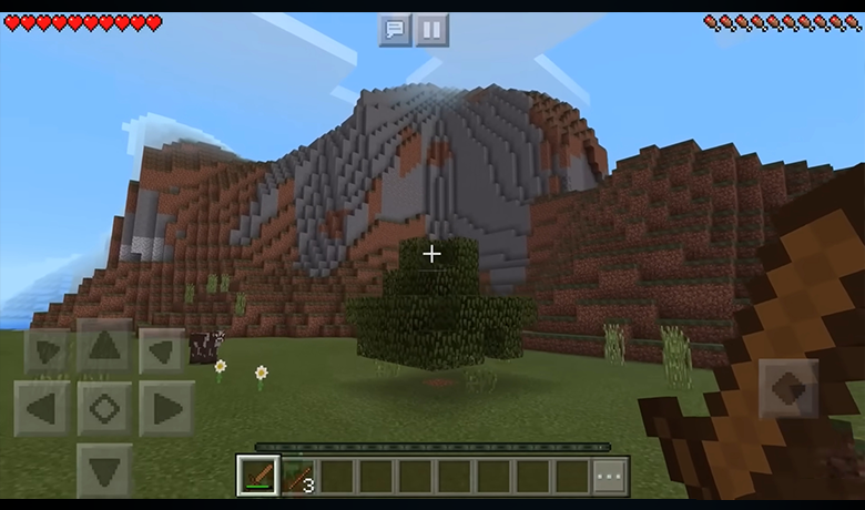 Screenshot containing a mountain and vegetation around it both formed by cubes